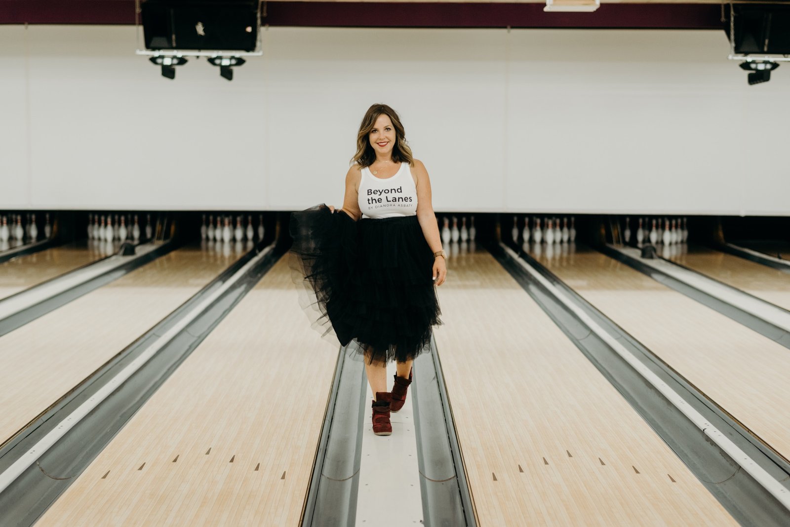 Diandra Asbaty in a Beyond the Lanes tank and tulle skirt walking down the lane